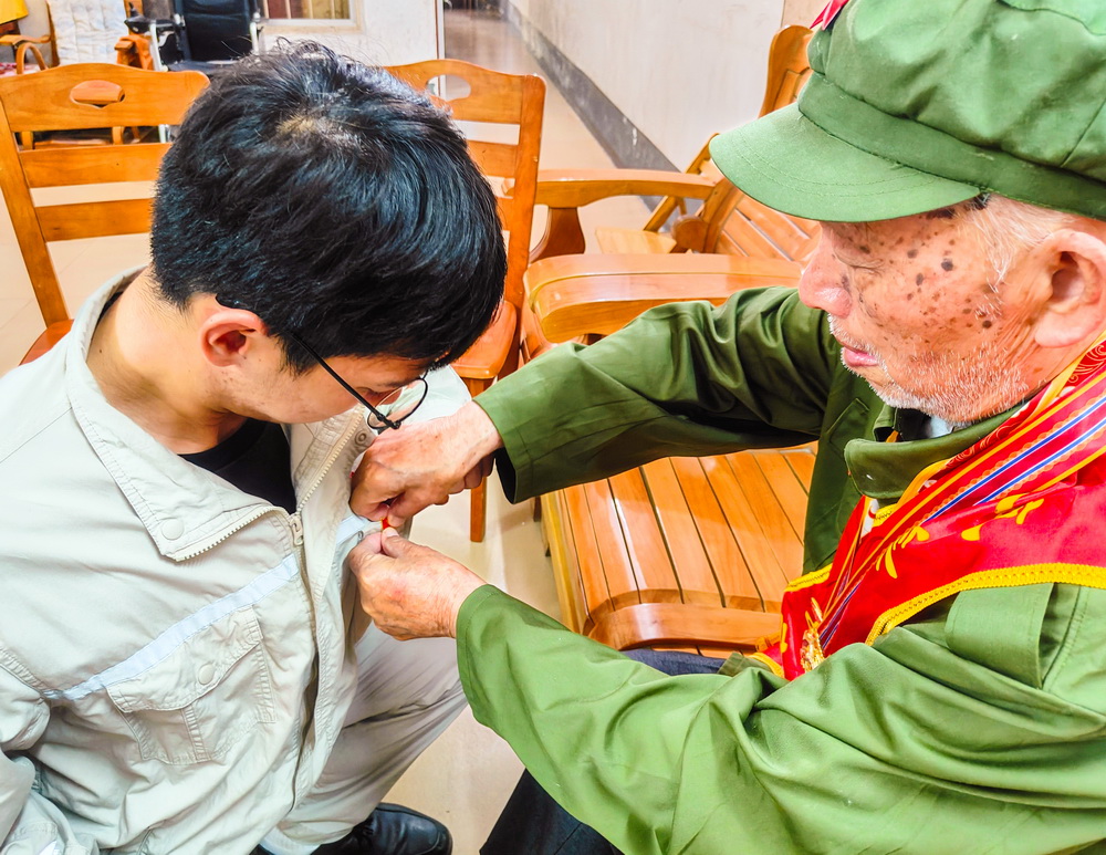 2、韋仕隆給新入黨的青年黨員佩戴黨章--李陽(yáng)攝.jpg